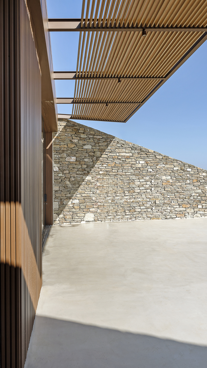 Außenraum mit Natursteinmauer. Foto: Panagiotis Voumvakis